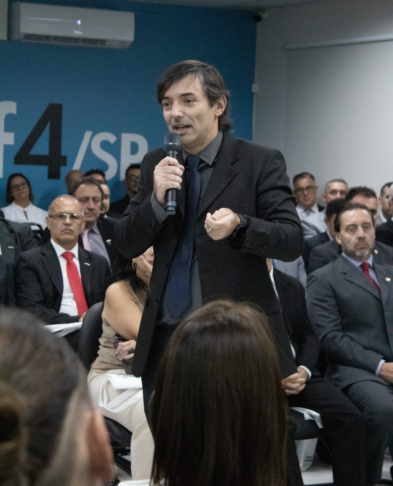 Cris Parente ao microfone em evento do CREF4/SP